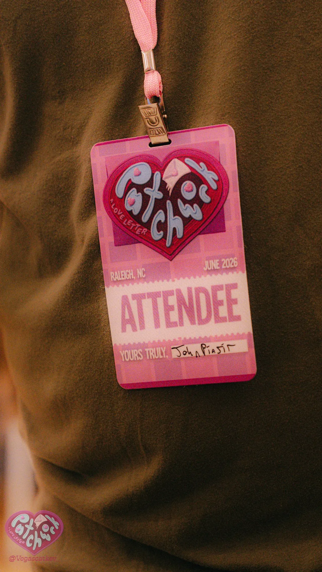 Patchwork attendee badge with the heart logo on a pink lanyard